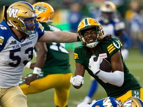 Edmonton Elks defensive back Duron Carter (8) is tackled by Winnipeg Blue Bombers’ Patrick Neufeld (53) after an interception at Commonwealth Stadium in Edmonton on July 22, 2022.