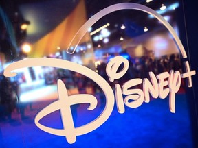 In this file photo taken Sept. 9, 2022, fans are reflected in the Disney+ logo during the Walt Disney D23 Expo in Anaheim, Calif.