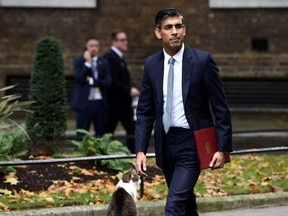Britain's new Prime Minister Rishi Sunak walks past Larry the cat outside Number 10 Downing Street, in London, Tuesday, Oct. 25, 2022.