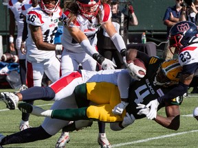 Edmonton Elks running back Kevin Brown (4) is tackled by Montreal Alouettes defensive lineman Michael Wakefield (96) at Commonwealth stadium in Edmonton on Saturday, Oct. 1, 2022.