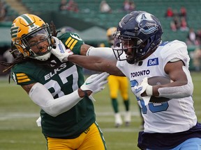 Toronto Argonauts wide receiver Cam Phillips, right, evades a tackle from Edmonton Elks defensive back Treston Decoud during Canadian Football League game action in Edmonton on Saturday, Oct. 15, 2022.