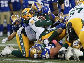 Edmonton Elks quarterback Kai Locksley (10) gets pushed back by Winnipeg Blue Bombers' Deatrick Nichols (1) as he attempts the short yardage down during first half CFL action in Winnipeg Saturday, October 8, 2022.