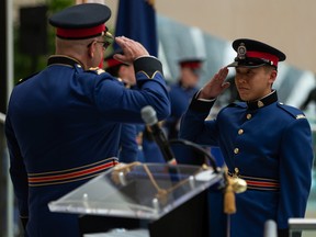 Const. Benjamin Leung, right, salutes Chief Dale McFee during Edmonton Police Service Recruit Training Class No. 153's graduation ceremony at city hall in Edmonton on May 13, 2022.