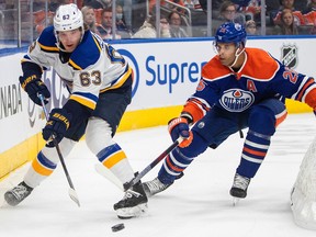 St. Louis Blues' Jake Neighbours (63) and Edmonton Oilers' Darnell Nurse (25) battle for the puck during first period NHL action in Edmonton on Saturday, October 22, 2022.