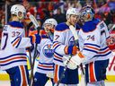 Edmonton Oilers goaltender Stuart Skinner (74) and center Connor McDavid (97) celebrate a win with teammates against the Calgary Flames at Scotiabank Saddledome on Oct. 29, 2022. 