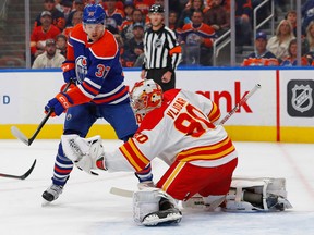 Calgary Flames goaltender Dan Vladar (80) makes a save while Edmonton Oilers forward Warren Foegele (37) looks for a rebound during the first period at Rogers Place on Oct. 15, 2022.