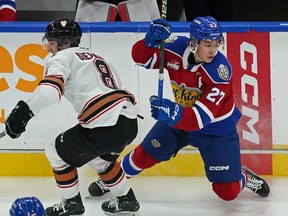 Edmonton Oil Kings Rhett Melnyk (right) evades a check by Calgary Hitmen Grayden Siepmann during WHL hockey action in Edmonton on Friday October 28, 2022.