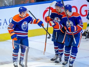 Edmonton Oilers Tyson Barrie (22) celebrates his goal with Dylan Holloway (55) and Zach Hyman (18) against the Vancouver Canucks during second period pre-season action on Monday, Oct. 3, 2022 in Edmonton.