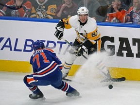 Pittsburgh Penguins captain Sidney Crosby (87) is checked by Edmonton Oilers Ryan McLeod (71) during first period National Hockey League game action in Edmonton on Monday October 24, 2022. The Oilers defeated the Penguins 6-3.