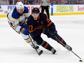 The Edmonton Oilers' Connor McDavid (97) battles the Buffalo Sabres' Kyle Okposo (21) during third period NHL action at Rogers Place in Edmonton, Tuesday Oct. 18, 2022. The Sabres won 4 to 2. Photo By David Bloom