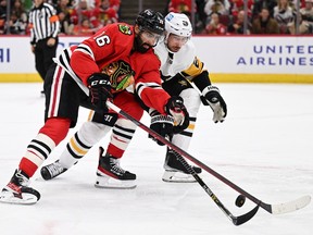 Jujhar Khaira #16 of the Chicago Blackhawks and Marcus Pettersson #28 of the Pittsburgh Penguins battle for control of the puck in the second period on Nov. 20, 2022 at United Center in Chicago, Illinois.