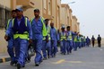 Foreign laborers working on the construction site of the al-Wakrah football stadium, one of the Qatar's 2022 World Cup stadiums, walk back to their accomodation at the Ezdan 40 compound after finishing work on May 4, 2015, in Doha's Al-Wakrah southern suburbs.