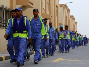 Foreign laborers working on the construction site of the al-Wakrah football stadium, one of the Qatar's 2022 World Cup stadiums, walk back to their accomodation at the Ezdan 40 compound after finishing work on May 4, 2015, in Doha's Al-Wakrah southern suburbs.
