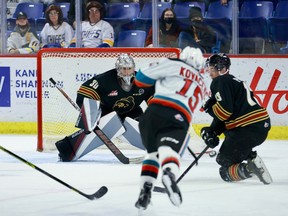 Rilen Kovacevic (15) of the Kelowna Rockets shoots on Vancouver Giants goalie Jesper Vikman as Damian Palmieri (13)  goes for the block on Oct. 29, 2021, at the Langley Events Centre.