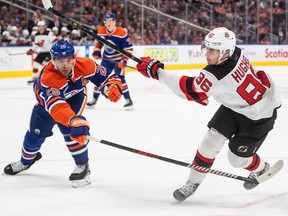 New Jersey Devils' Jack Hughes (86) is poke checked by Edmonton Oilers' Darnell Nurse (25) during first period NHL action in Edmonton on Thursday, November 3, 2022.