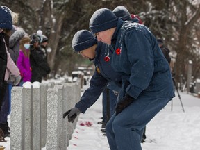 Students from Riverbend School in Edmonton and members of Cadets Canada leave poppies on the headstones of fallen soldiers as they observe the 12th annual Remembrance Day ceremony for No Stone Left Alone at Beechmount Cemetery on Monday, Nov. 7, 2022.