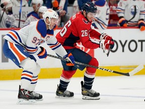 Edmonton Oilers center Connor McDavid, left, and Washington Capitals center Nic Dowd chase for possession of the puck in the first period of an NHL hockey game, Monday, Nov. 7, 2022, in Washington.