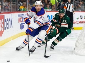 Connor McDavid #97 of the Edmonton Oilers passes the puck while Alex Goligoski #33 of the Minnesota Wild defends in the first period of the game at Xcel Energy Center on Thursday, Dec. 1, 2022 in St Paul, Minnesota.