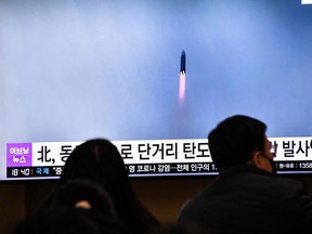 People watch a television screen showing a news broadcast with file footage of a North Korean missile test, at a railway station in Seoul on Dec. 23, 2022 after North Korea fired two short-range ballistic missiles according to South Korea's military.