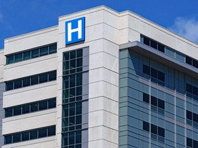 large modern building with blue letter H sign for hospital