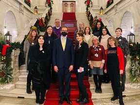 Avalon Heemskerk, front right, collected more than 1,000 signatures for a petition that was presented by NDP MLA Marlin Schmidt, front centre, in the Alberta legislature on Wednesday, Dec. 7, 2022, to urge that government to declare a state of public health emergency in response to the opioid crisis and ask for solutions to this problem. She and her family were moved to action following the death of her brother, Sebastian, from an overdose.