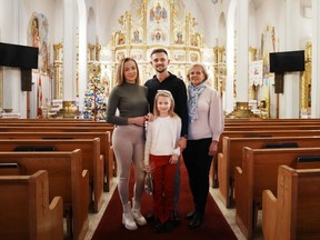Vitali Hrechka poses for a photo with his wife Evelina, daughter Emiliia, and mother Hanna, after the St. Nicholas Day celebration at St. Demetrius Ukrainian Orthodox Church in Toronto on Sunday, Dec. 18, 2022. The family recently arrived in Canada after leaving their home in Ukraines Transkarpathia region.