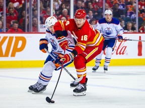 Calgary Flames defenseman Nikita Zadorov (16) and Edmonton Oilers center Klim Kostin (21) battle for the puck during the first period at Scotiabank Saddledome on Dec. 27, 2022.