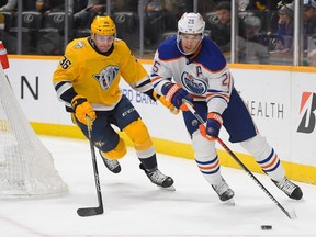 Edmonton Oilers defenceman Darnell Nurse (25) skates as Nashville Predators left wing Cole Smith (36) gives chase during the first period at Bridgestone Arena on Dec. 13, 2022.
