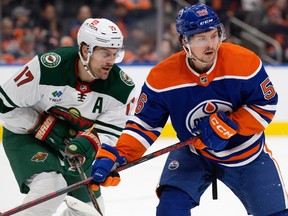 Kailer Yamamoto (56) of the Edmonton Oilers battles the Minnesota Wild's Marcus Foligno (17) during first period NHL action in Edmonton on Dec. 9, 2022.