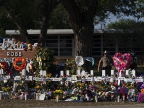 Flowers and candles are placed around crosses on May 28, 2022, at a memorial outside Robb Elementary School in Uvalde, Texas.