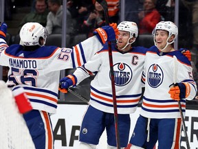 ANAHEIM, CALIFORNIA - JANUARY 11: Connor McDavid #97 and Kailer Yamamoto #56 congratulate Dylan Holloway #55 of the Edmonton Oilers during the first period of a game against the Anaheim Ducks at Honda Center on January 11, 2023 in Anaheim, California.