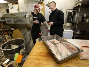 (left to right) Line cook Richard Crouse and Chef Oleh Durkach, use Google Translate on their mobile phones to communicate in the kitchen at the Norwood Legion, in Edmonton Thursday Jan. 5, 2023. Durkach, who recently arrived from Ukraine, is cooking a traditional Ukrainian meals for Christmas dinners at the legion.