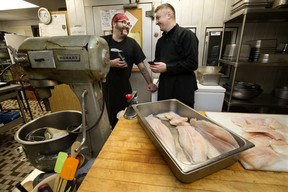 (left to right) Line cook Richard Crouse and Chef Oleh Durkach, use Google Translate on their mobile phones to communicate in the kitchen at the Norwood Legion, in Edmonton Thursday Jan. 5, 2023. Durkach, who recently arrived from Ukraine, is cooking a traditional Ukrainian meals for Christmas dinners at the legion.