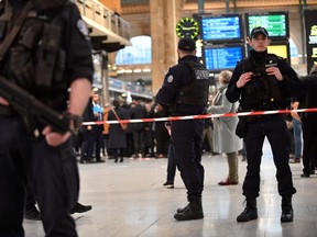 French police stand guard in a cordoned off area at Paris' Gare du Nord train station, after several people were lightly wounded by a man wielding a knife on January 11, 2023.
