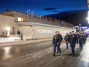 Employees of a private security company walk outside Davos Congress Centre, the venue of the World Economic Forum 2023, in Davos, Switzerland, Saturday, Jan. 14, 2023.