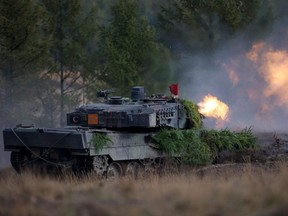 A Leopard 2 main battle tank of the German armed forces Bundeswehr shoots during a visit by German Chancellor Olaf Scholz during a training exercise at the military ground in Ostenholz, Germany, Oct. 17, 2022.