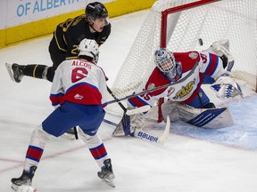 The Edmonton Oil Kings' Parker Alcos and Brandon Wheat Kings captain Nate Danielson battle for the puck in front of goaltender Logan Cunningham at Rogers Place on Sunday, Jan. 22, 2023.