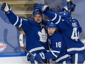 Toronto Maple Leafs centre Auston Matthews is congratulated by teammates Mitchell Marner and Morgan Rielly after scoring the game winning goal during overtime NHL action against the Winnipeg Jets in Toronto on Thursday, March 11, 2021.