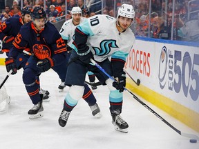 Seattle Kraken forward Matty Beniers (10) protects the puck from Edmonton Oilers defencemen Darnell Nurse (25) during the second period at Rogers Place on Jan. 3, 2023.