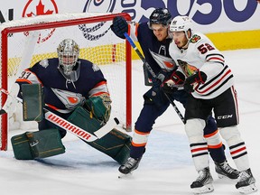 Chicago Blackhawks forward Reese Johnson (52) battles with Edmonton Oilers defensemen Philip Broberg (86) in front on Edmonton Oilers emergency backup goaltender Matt Berlin (33) during the third period at Rogers Place on Jan. 29, 2023.