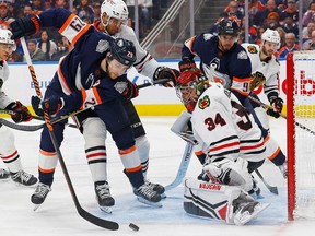 Edmonton Oilers forward Leon Draisaitl (29) goes for a loose puck in front of Chicago Blackhawks goaltender Petr Mrazek (34) during the third period at Rogers Place on Jan. 29, 2023.