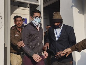 Policemen escort Shankar Mishra, arrested for being an unruly airline passenger, outside a court in New Delhi, Saturday, Jan. 7, 2023. Indian police arrested Mishra following a complaint by a woman aboard an Air India flight from New York that he urinated on her in business class.