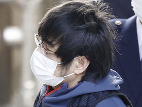 Tetsuya Yamagami, the alleged assassin of Japan's former Prime Minister Shinzo Abe, is led by police officers into a police station in Nara, Japan, Tuesday, Jan. 10, 2023.