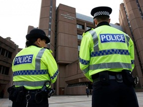 Police officers stand guard outside Liverpool Crown Court, in Liverpool, England, Oct. 3, 2022.
