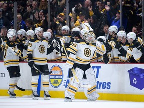 Linus Ullmark of the Boston Bruins is congratulated at the bench after scoring a goal into an empty net against the Vancouver Canucks on Feb. 25.