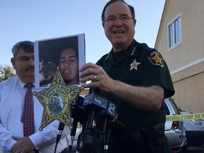 Polk County (Florida) Sheriff Grady Judd holds a picture of a mass shooting suspect who died during a confrontation with police.