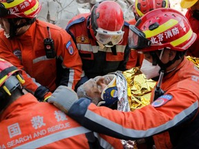 Turkish and Chinese rescuers carry Malek, a 55-year-old Syrian refugee man, into an ambulance after he was rescued from the wreckage of a destroyed building in the aftermath of the deadly earthquake in Hatay, Turkey Feb. 12, 2023.