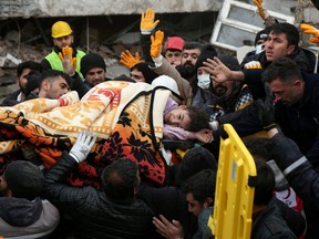 Rescuers carry out a girl from a collapsed building following an earthquake in Diyarbakir, Turkey, Monday, Feb. 6, 2023.