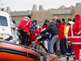 Bodies are moved from a coast guard boat in the aftermath of a deadly migrant shipwreck, at the port in Le Castella, Italy, February 27, 2023.