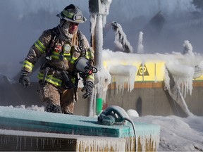 Firefighters continue to work at the scene of house fire at 223 and 235 Glenridding Ravine Road SW in Edmonton, Friday Feb. 24, 2023. Photo By David Bloom